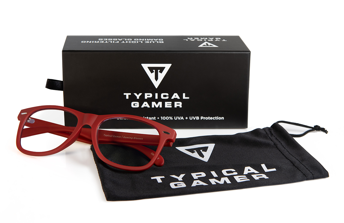 Typical Gamer Eyewear Raptor in red next to box and slip case with Typical Gamer Logo.