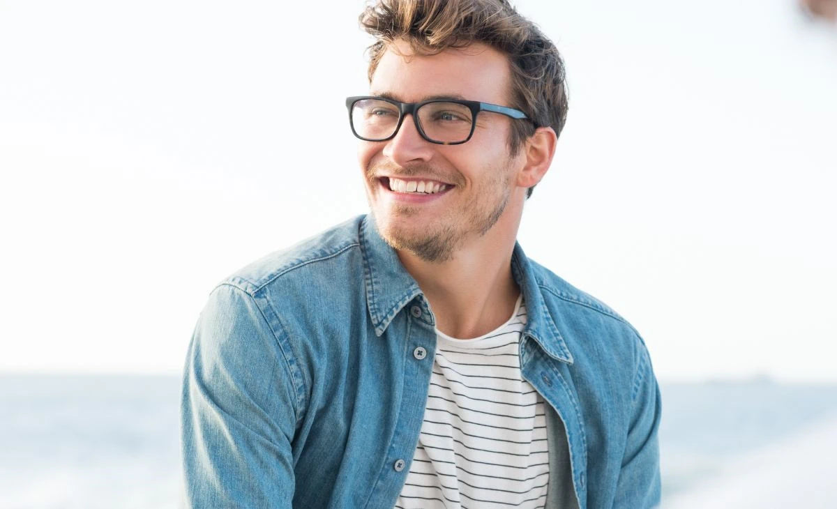 Man wearing ICU Eyewear reading glasses smiling while looking to his right.  